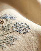 Close-up of embroidered fabric with floral patterns on a beige background