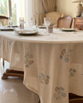 Dining table set with a floral-patterned tablecloth in a home setting.