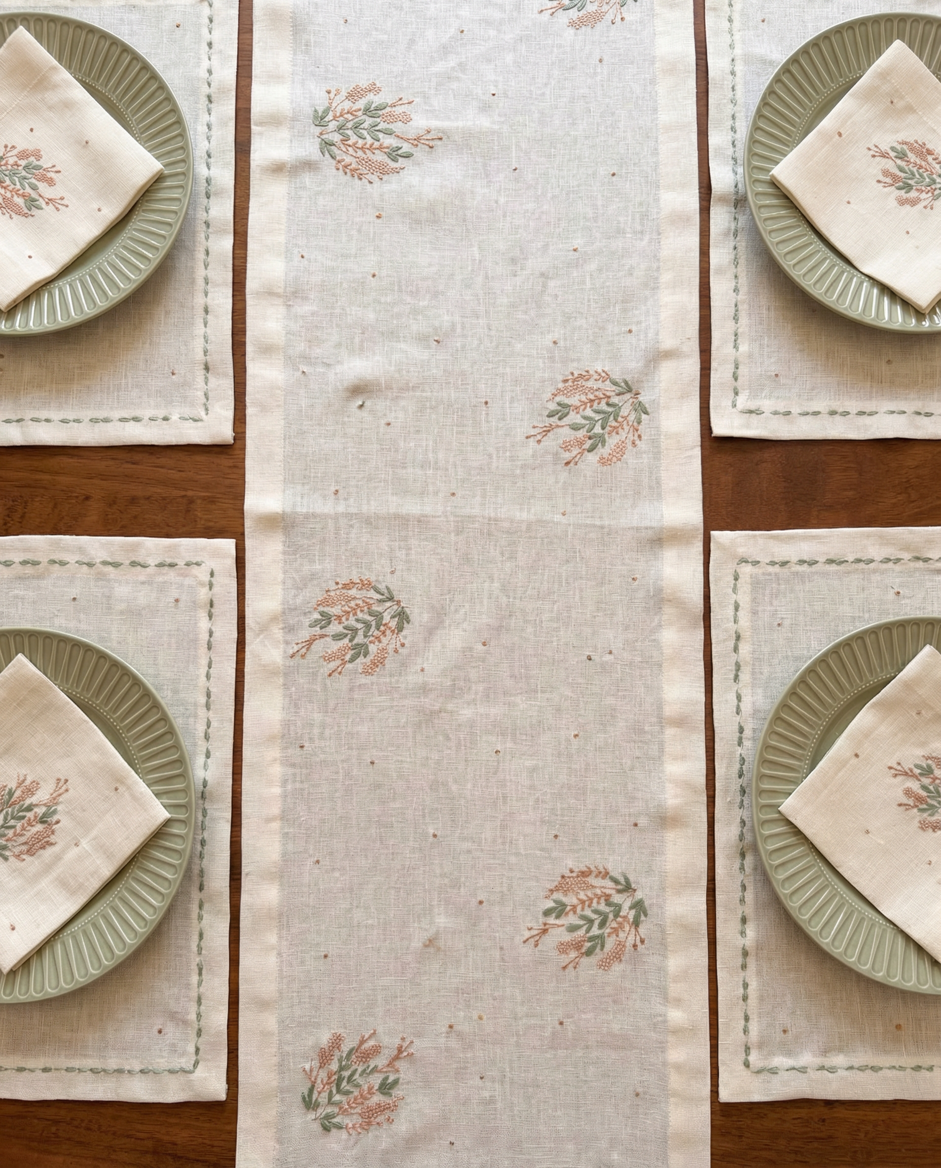 Table setting with floral-patterned placemats and plates on a wooden table.