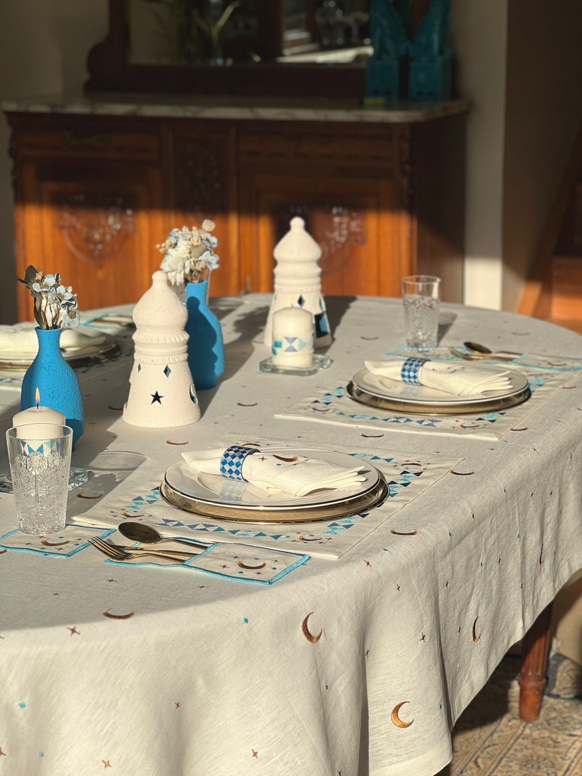 ramadan Dining table set with blue and white decor, including plates, glasses, and cutlery.